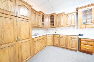 Kitchen display featuring hickory cabinets, Corian countertops, and a stone backsplash