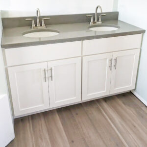 Bathroom remodeling project featuring custom wood cabinetry, warm gray quartz countertop, brushed nickel accessories