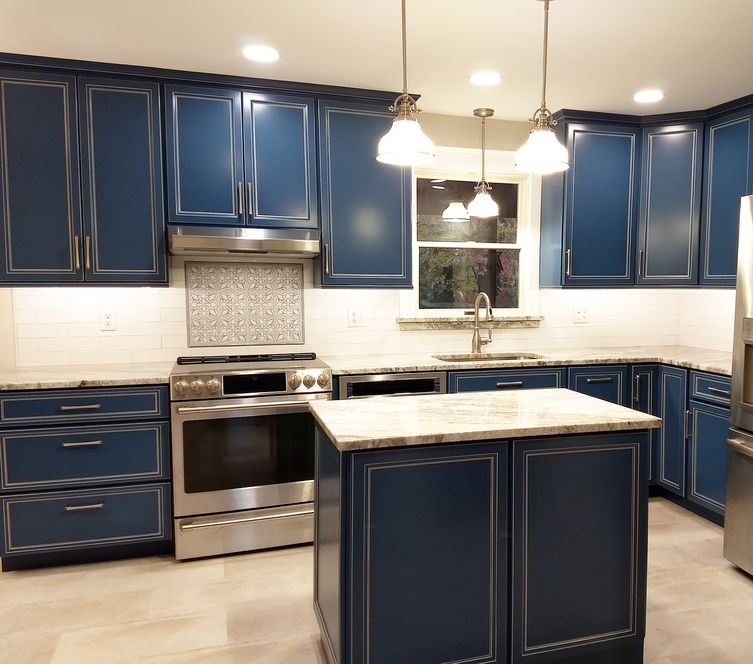 Home remodeling project featuring a kitchen with custom maple cabinetry painted blue, granite countertops, ceramic & marble backsplash, stainless / satin nickel accessories, and a hidden microwave