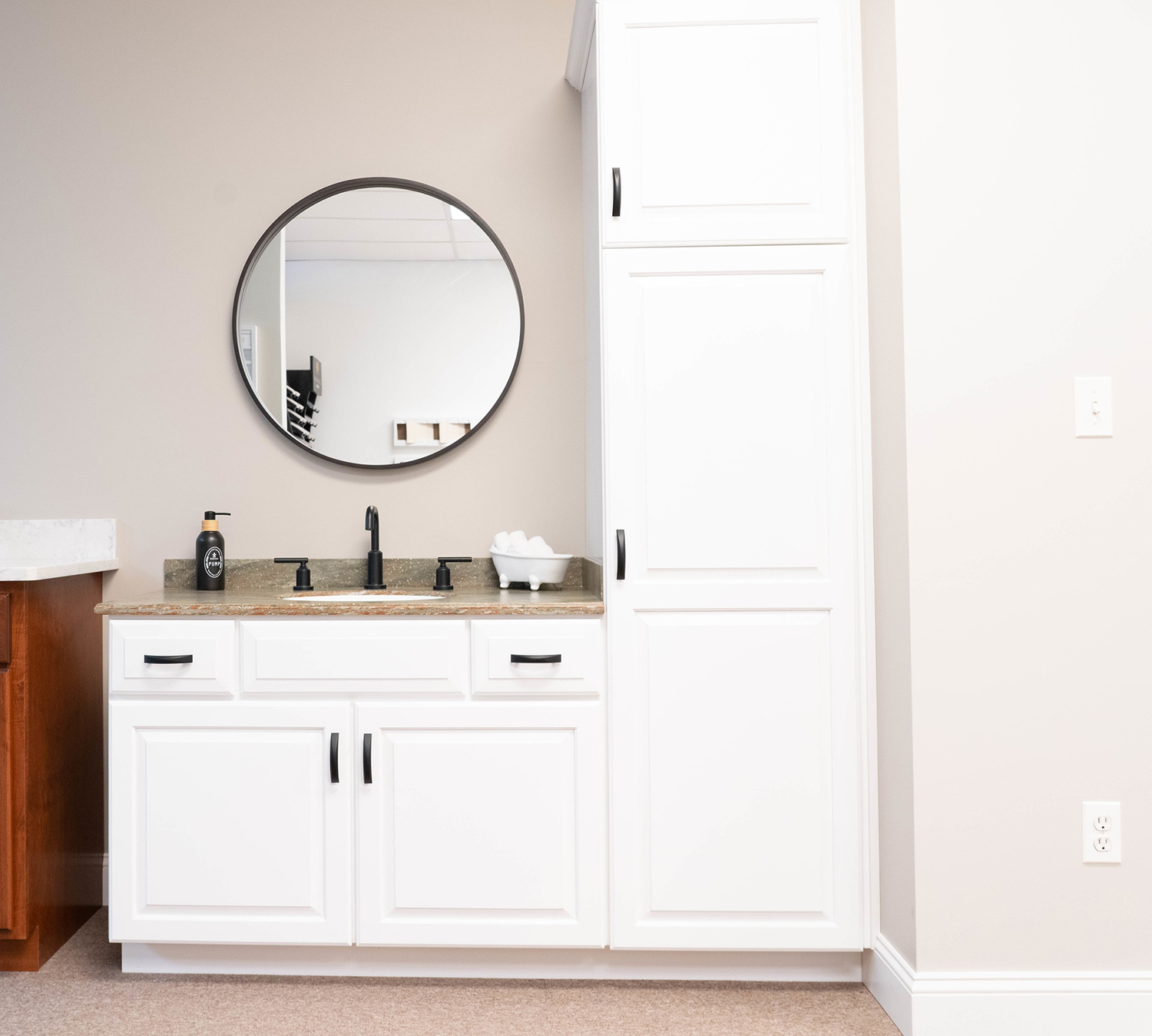Bathroom vanity display with white cabinets and Corian countertop